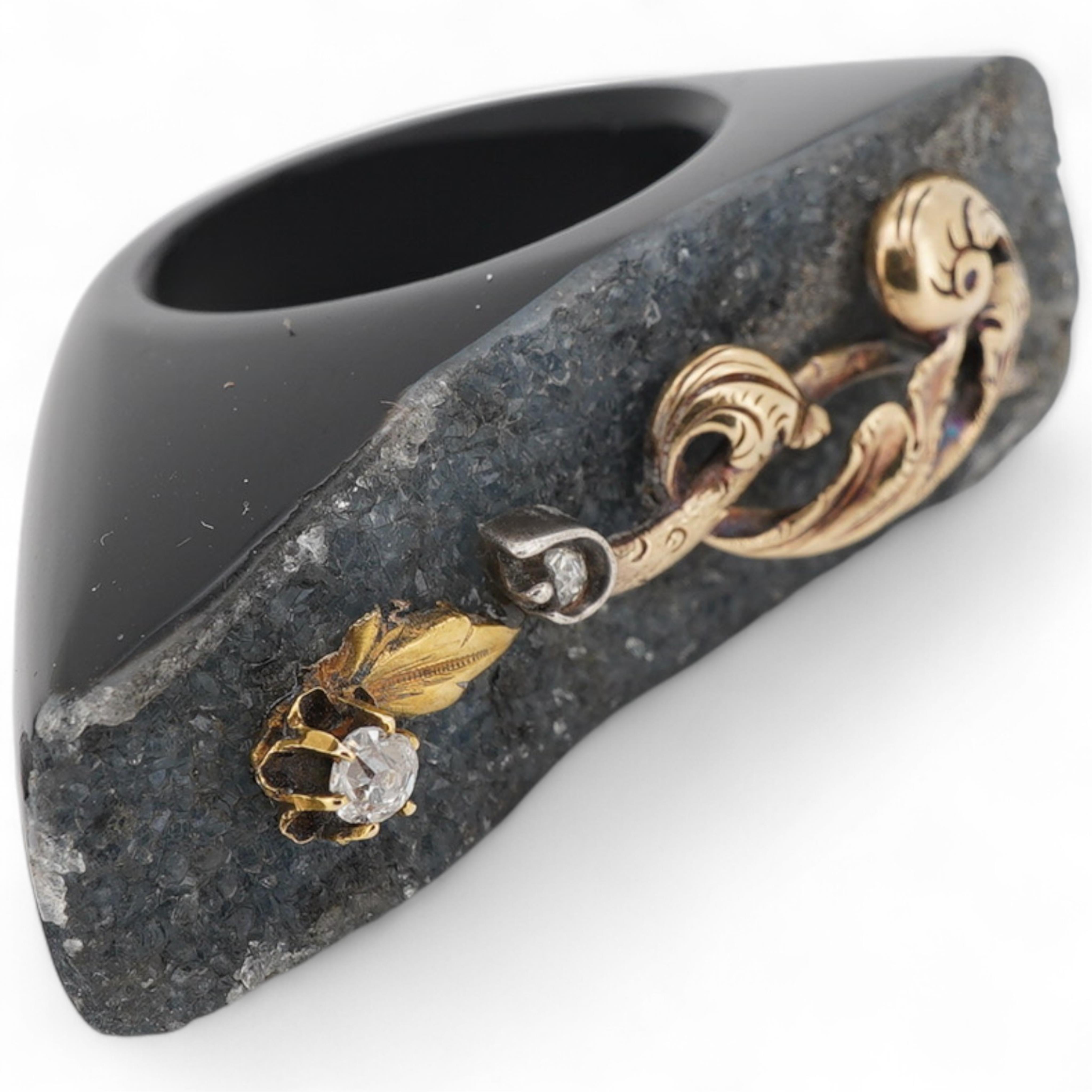 An unusual quartz ring, with a yellow metal and two stone diamond set scrolling foliate surmount, size N/O.